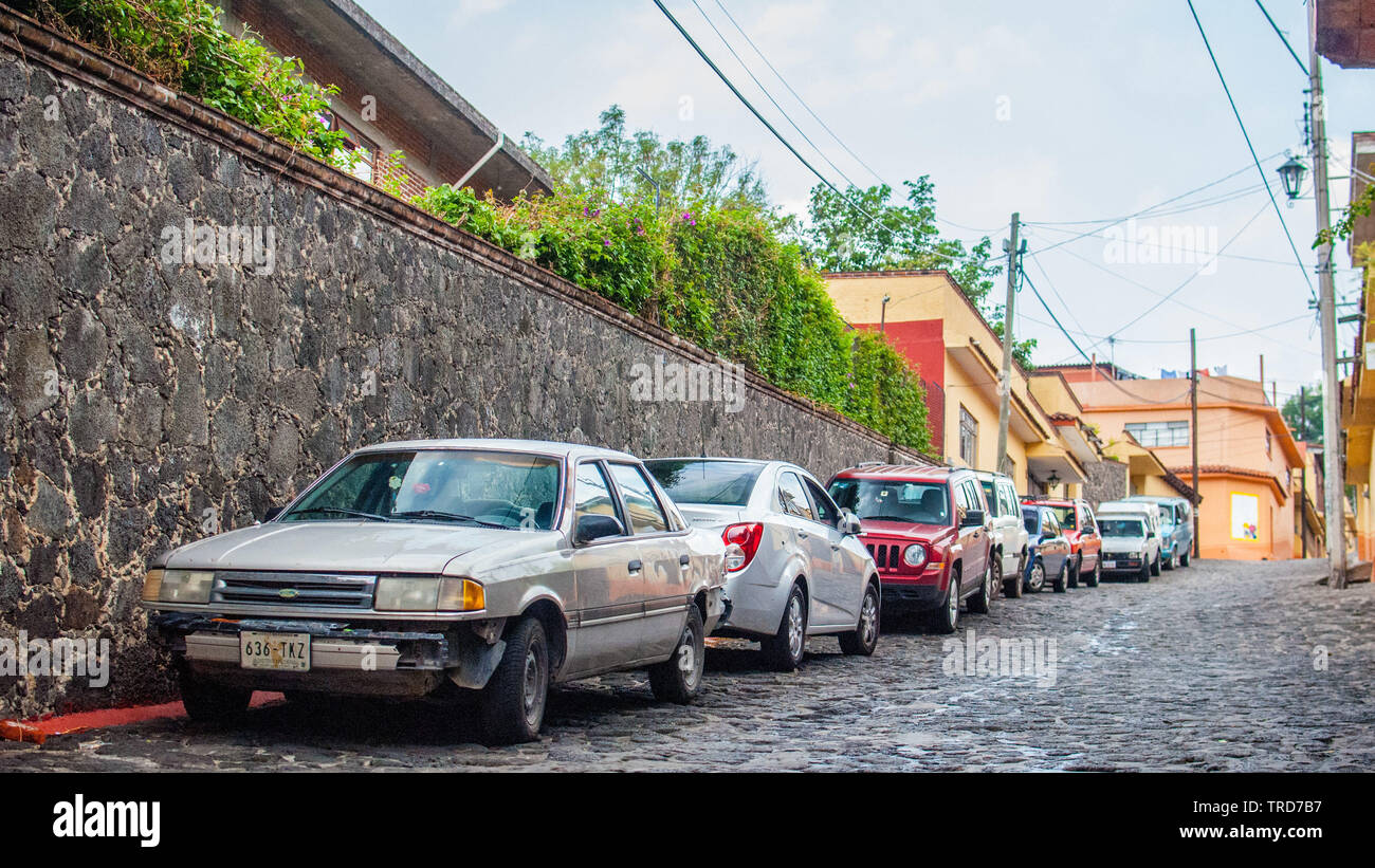 Low angle view of steep streets in Tepoztlan, stone streets and old vehicles Stock Photo