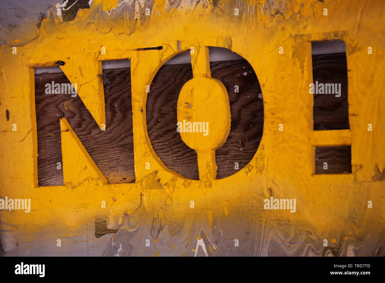 Stencil font signage with many layers of paint and textures with the words No! and yellow spray paint. Stock Photo