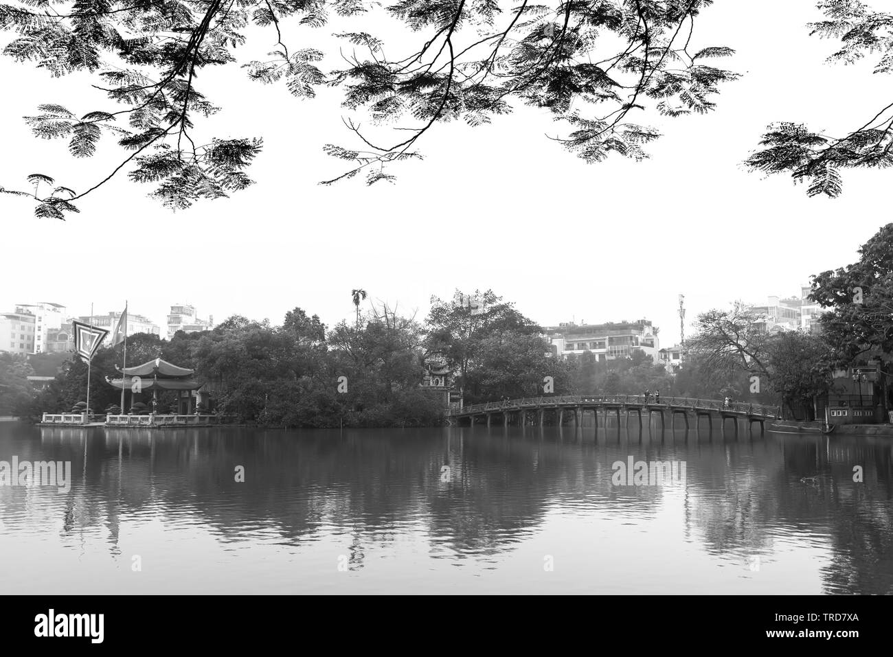 Architectural Huc Bridge looming shake trees lake with arched red crawfish culture symbolizes history thousands years in Hanoi, Vietnam Stock Photo