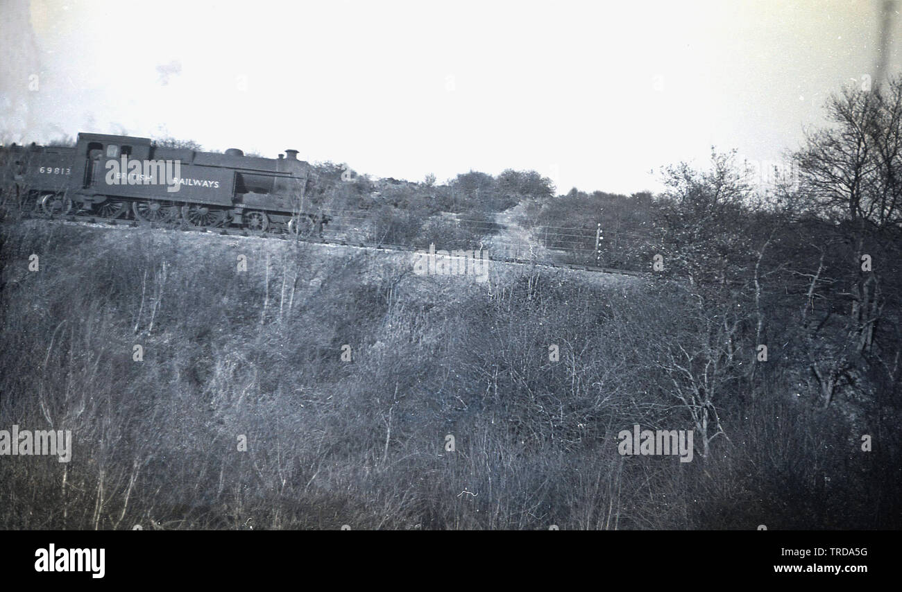 1950, historical, a British Railways steam locomotive 69813 going down a railway track on a gradient, England, UK. This  heavy freight locomotive was built at the Gorton Works in 1911 for Great Central Railways (GCR), later the LNER ( London & North Eastern Railway) - under the supervision of John G. Robinson and remained in service until 1960 when it was withdrawn as steam declined and the Beeching cuts of the railway network. Stock Photo