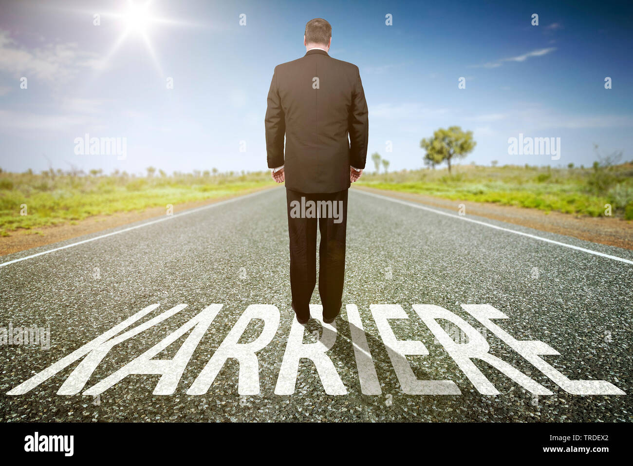 3D computer graphic, person standing on a straight highway section representing a path to a defined goal lettering KARRIERE (CAREER) Stock Photo