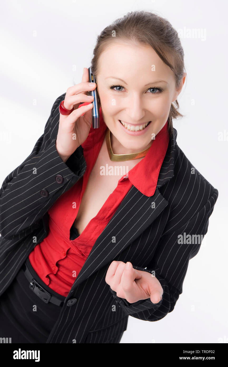 Portrait of a young likeable Business woman making a call with a cellphone and smiling into the camera Stock Photo
