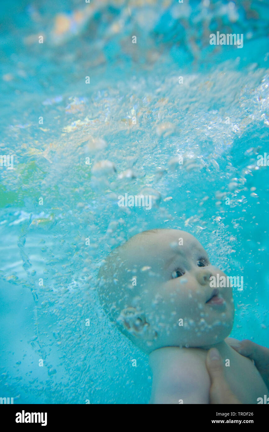 Underwater photography - baby be holding under water at a swimming lessons Stock Photo