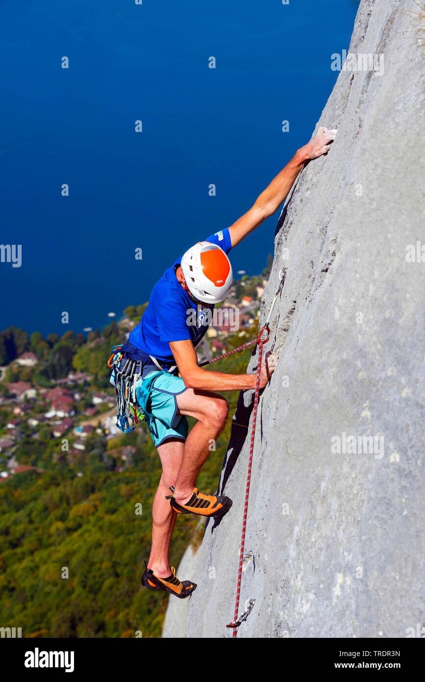 climber in a rock face over the Lake Annecy, France, Savoie Stock Photo