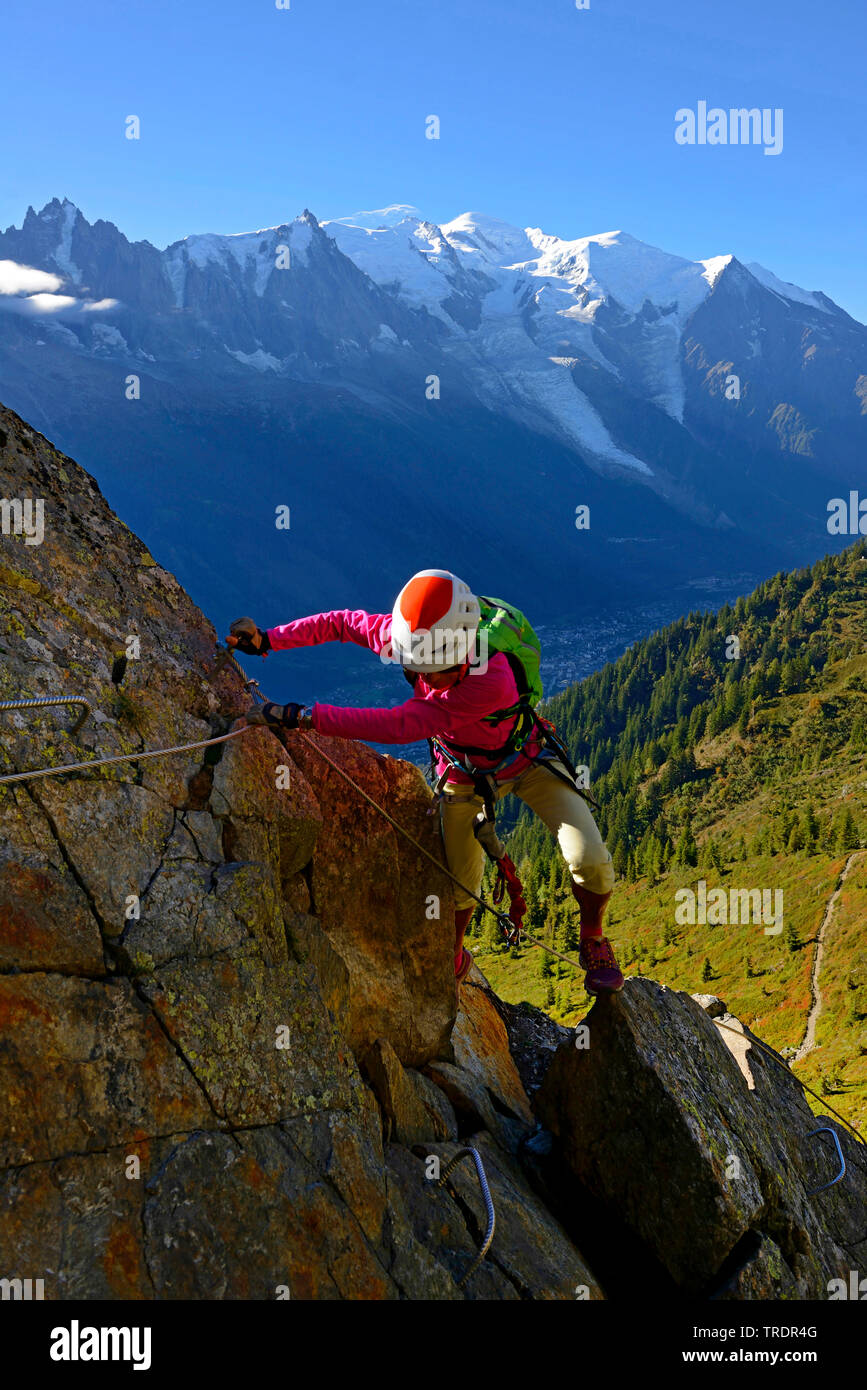 female climber on a rock, via ferrata des Evettes, Mont Blanc in background, France, Savoie, Chamonix Stock Photo