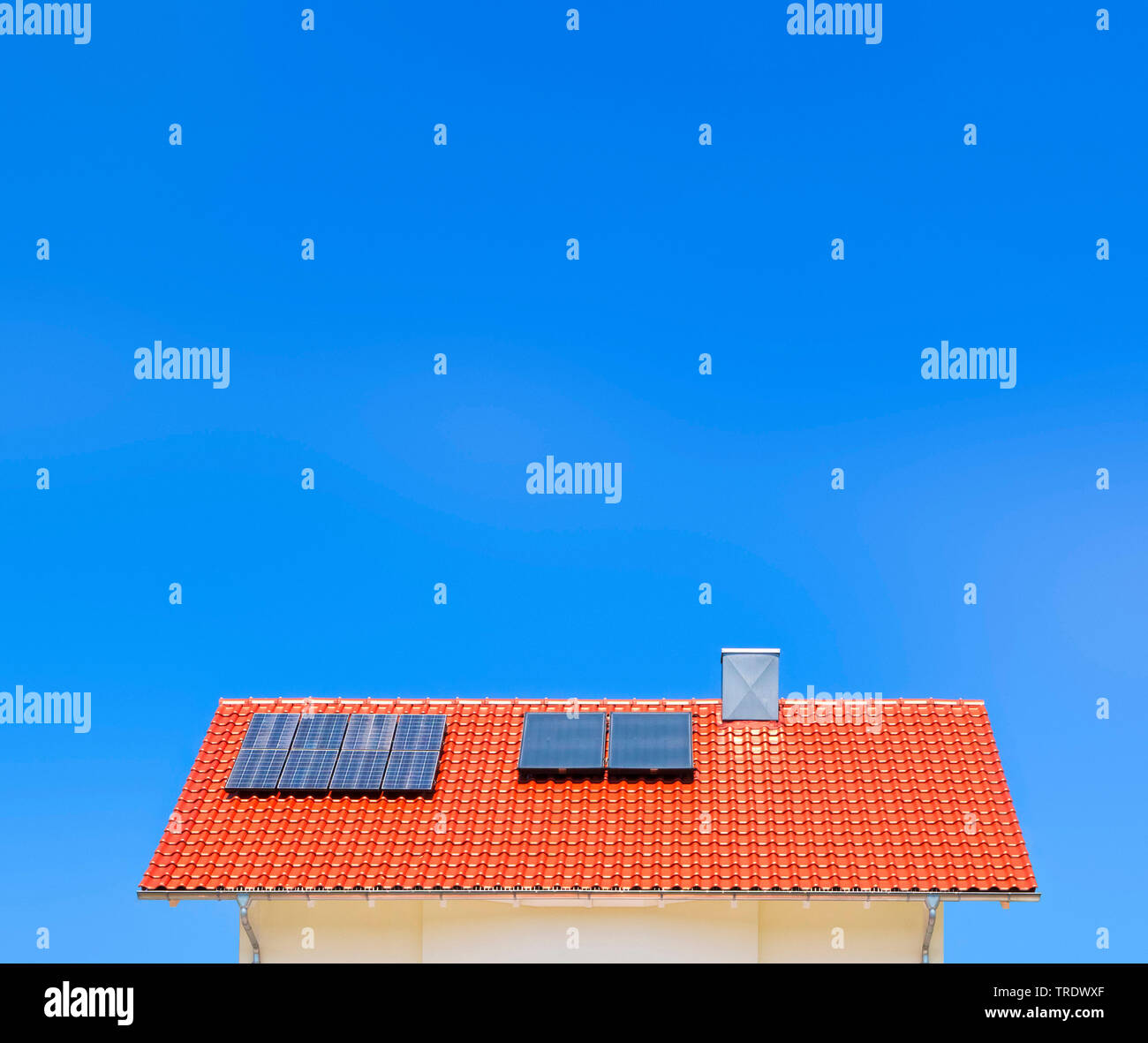 Detail of residental house roof with solar panels against blue sky Stock Photo