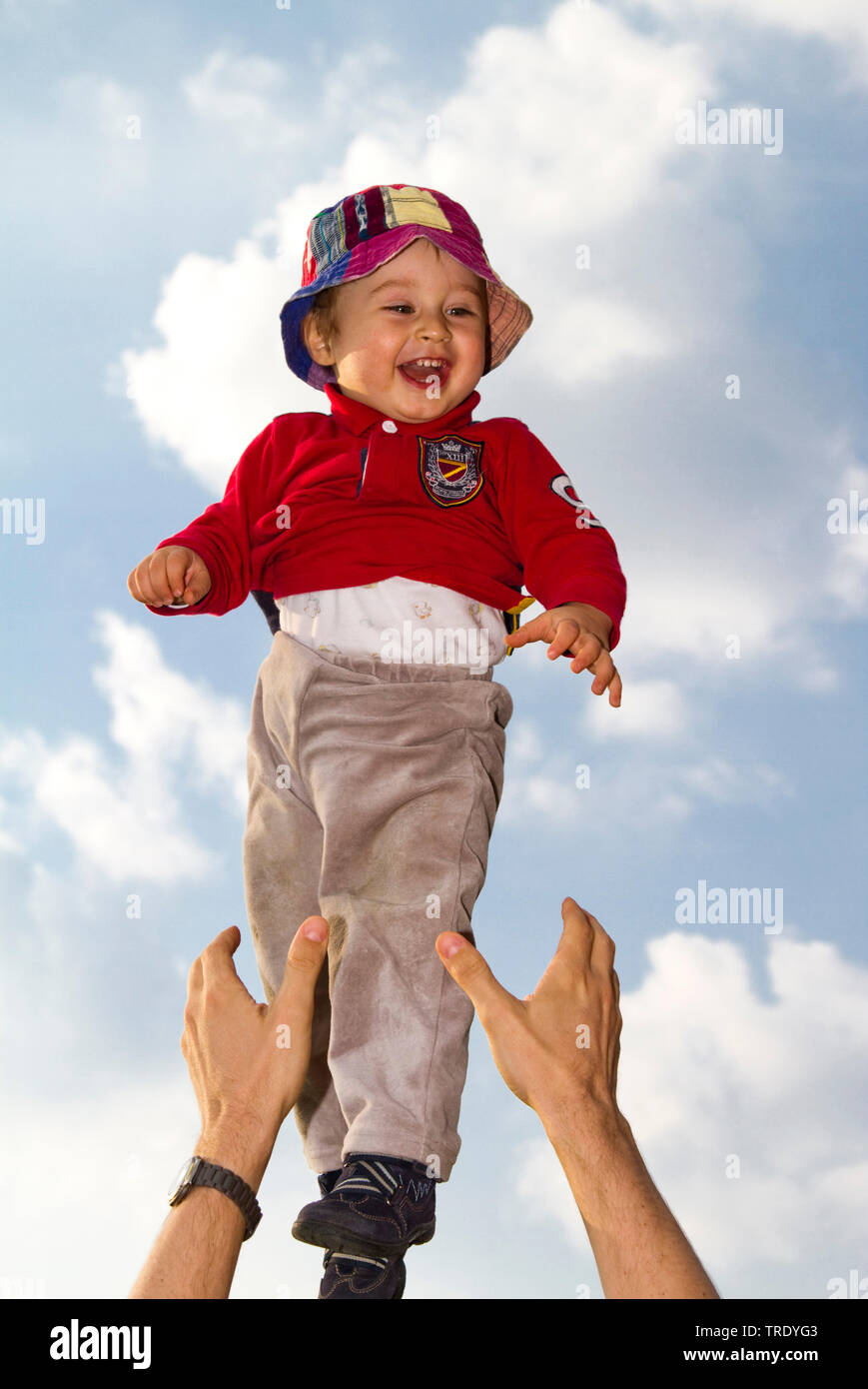 Portrait of a young boy thrown up into the air by an adult Stock Photo