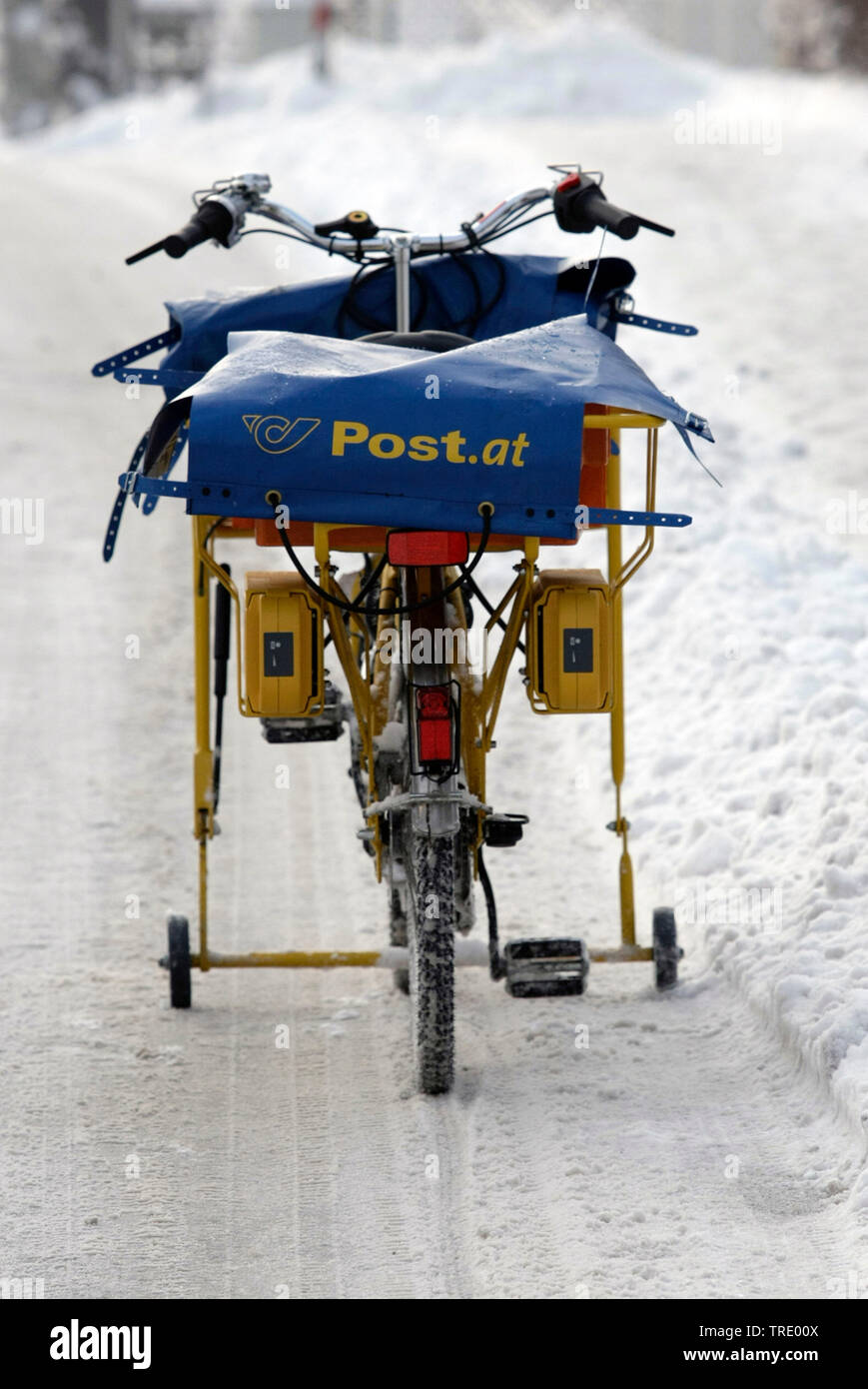 Postman's bike of the austrian Federal Mail on a snow-covered road, Austria Stock Photo