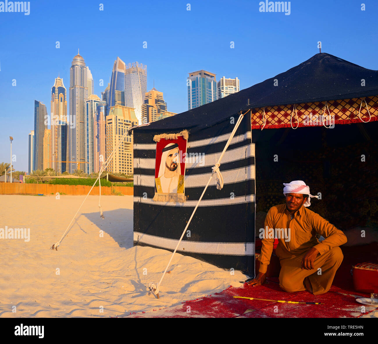bedouin man and his camp in front of skyscrapers of Dubai, United Arab Emirates, Dubai Stock Photo