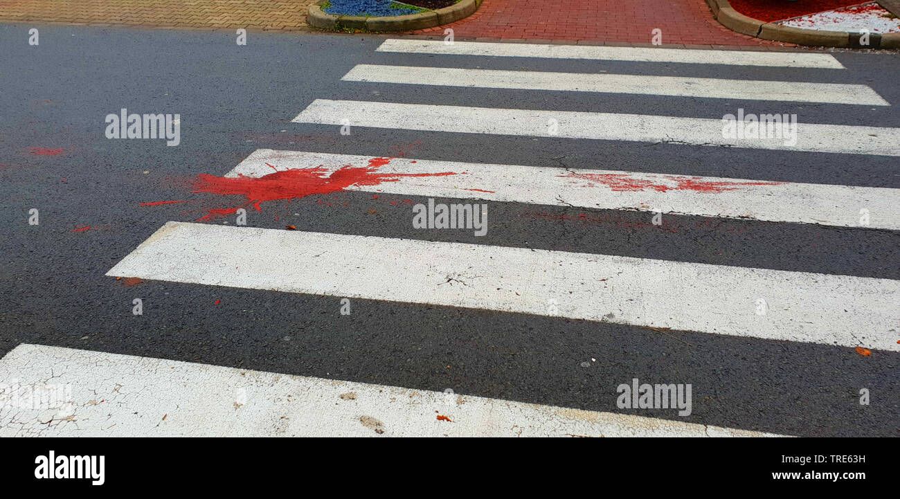 red paint blotch on a pedestrian crossing imitating a blood blood spot, black humor, Germany Stock Photo
