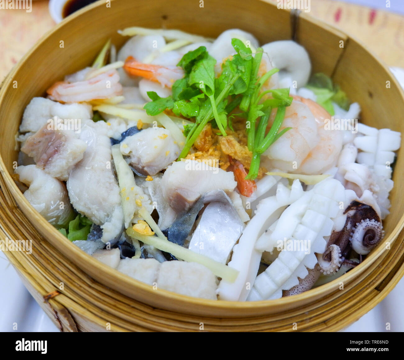 Steamed seafood with fish squid shrimp prawn on wooden steamer Stock