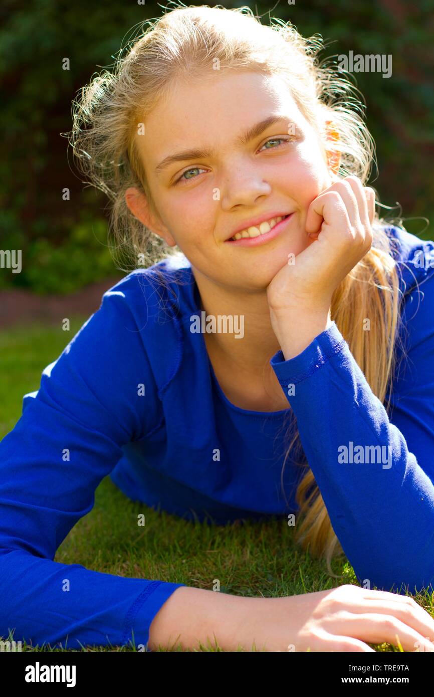 Young girl lying on the loan and resting her head on one hand Stock ...