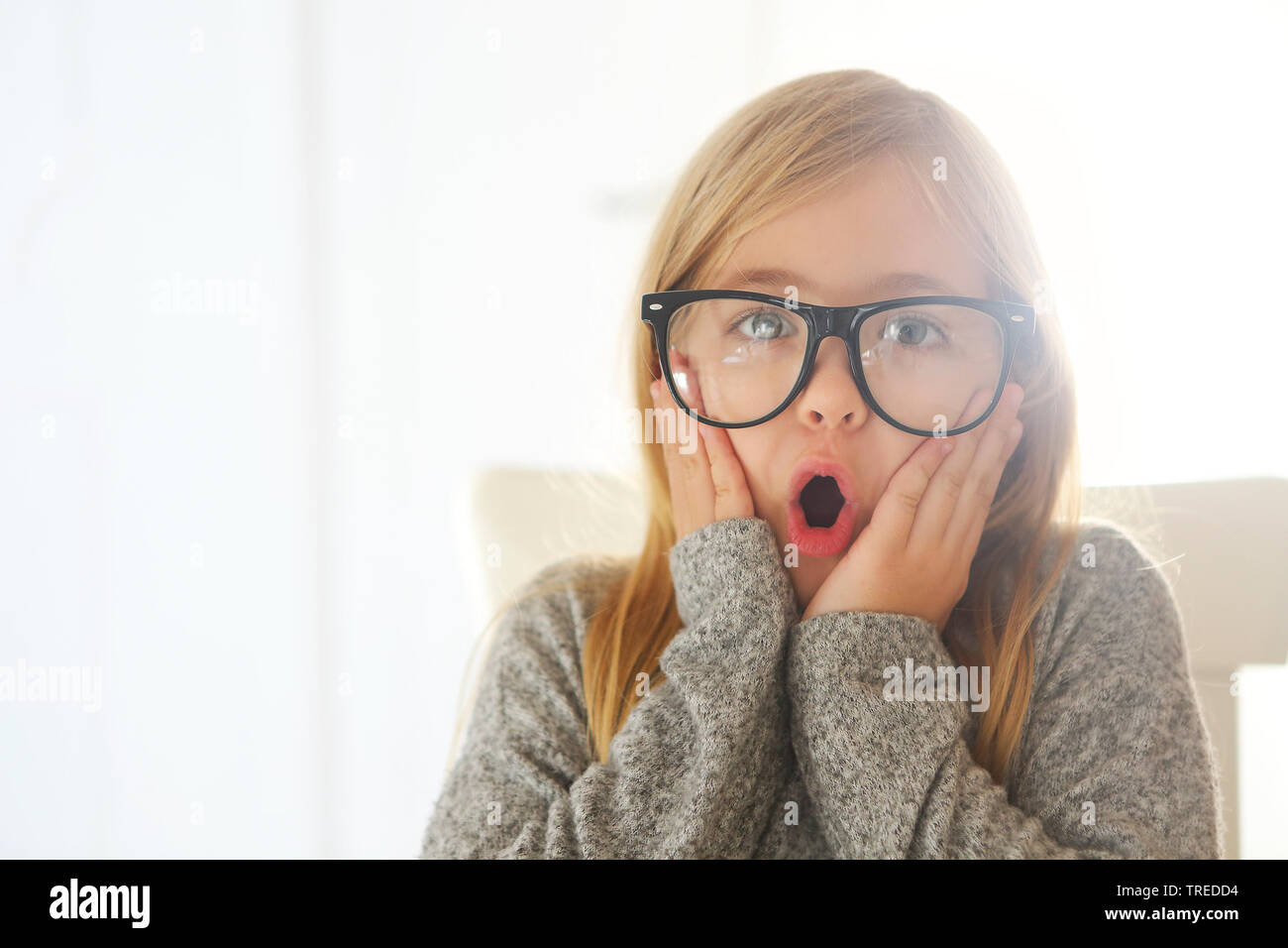 Smiling cute little girl with black eyeglasses over white background.  Education, school, childhood, people and vision concept Stock Photo