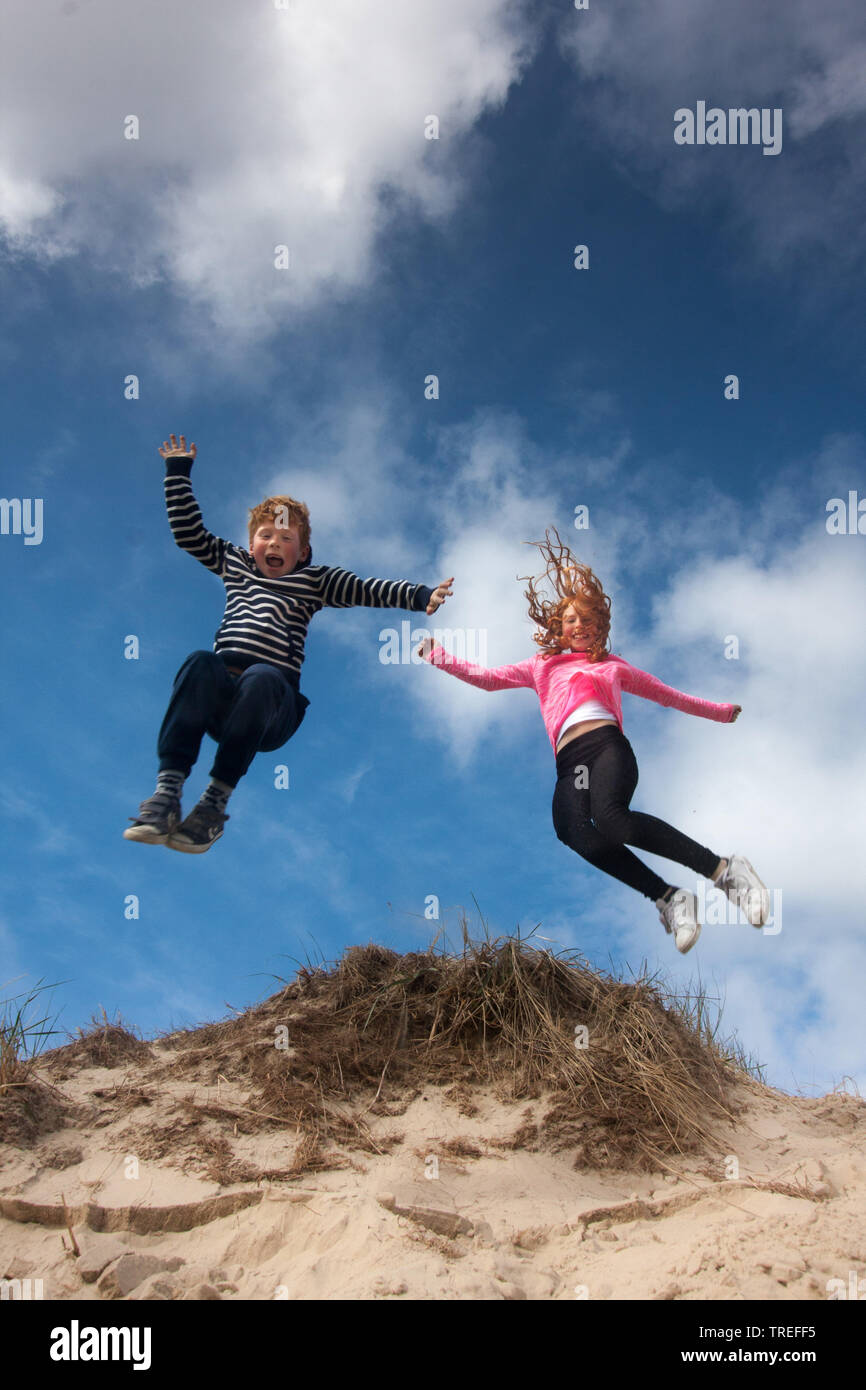 jumping kids in the dunes on Texel, Netherlands, Texel, De Slufter Stock Photo