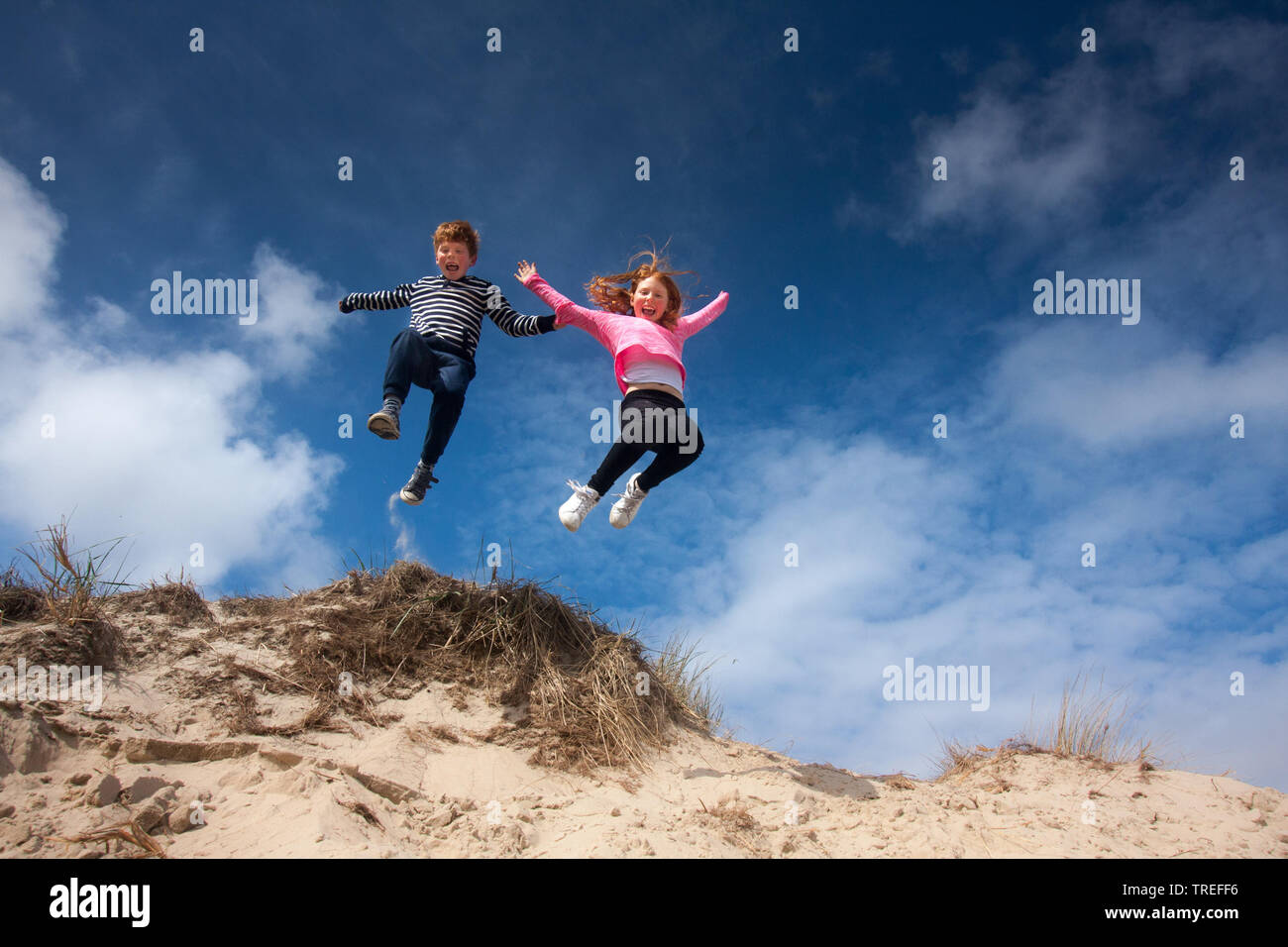 jumping kids in the dunes on Texel, Netherlands, Texel, De Slufter Stock Photo