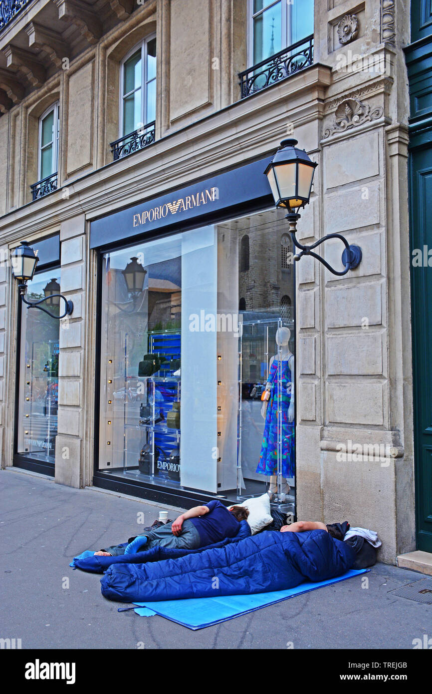 homeless sleeping in the street before a luxury boutique in Saint-Germain-des-Prés, Paris, France Stock Photo