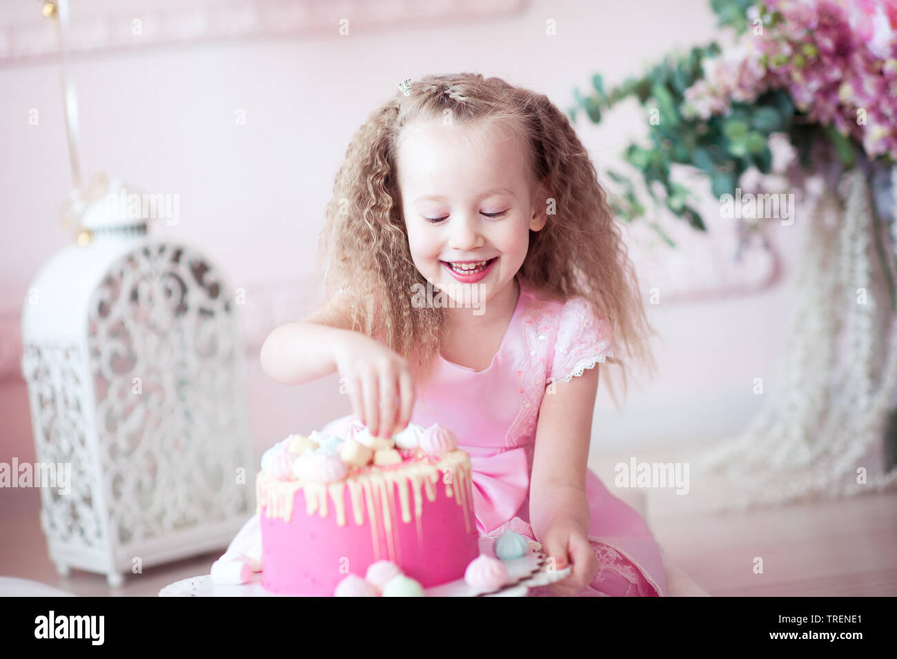 Laughing kid girl 5-6 year old eating birthday cake in room sitting on floor.  Looking at camera. Childhood Stock Photo - Alamy