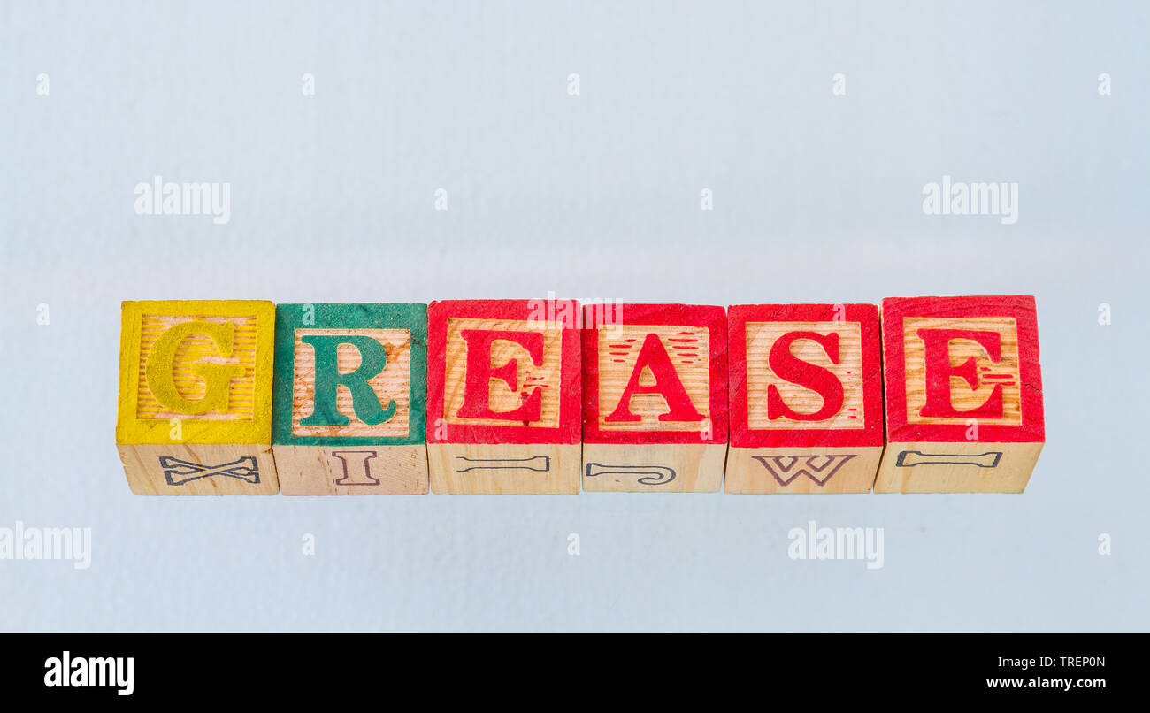The term grease visually displayed in colored toy blocks on a clear background image with copy space in landscape format Stock Photo