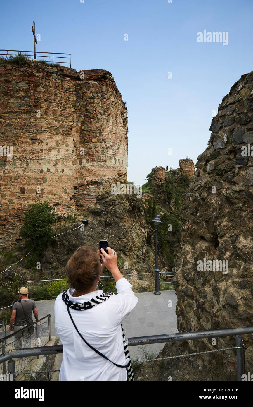 A woman taking a photo af an old church in Tbilisi. Georgia Stock Photo