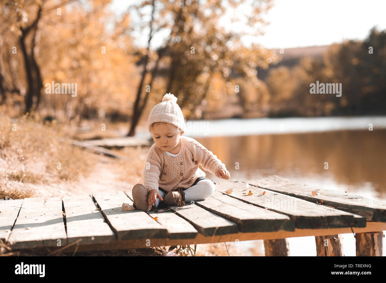 Baby girl 1 year old playing in autumn park. Wearing trendy knitted clothes  outdoors Stock Photo - Alamy
