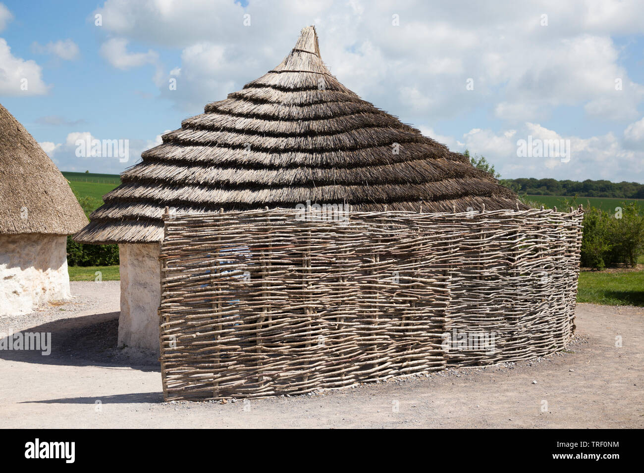 Exterior of recreated Neolithic stone age hut / stoneage huts with thatched roof / roofs. Village exhibition; Visitor centre Stonehenge  / Stone Henge. Amesbury, Wiltshire, UK (109) Stock Photo