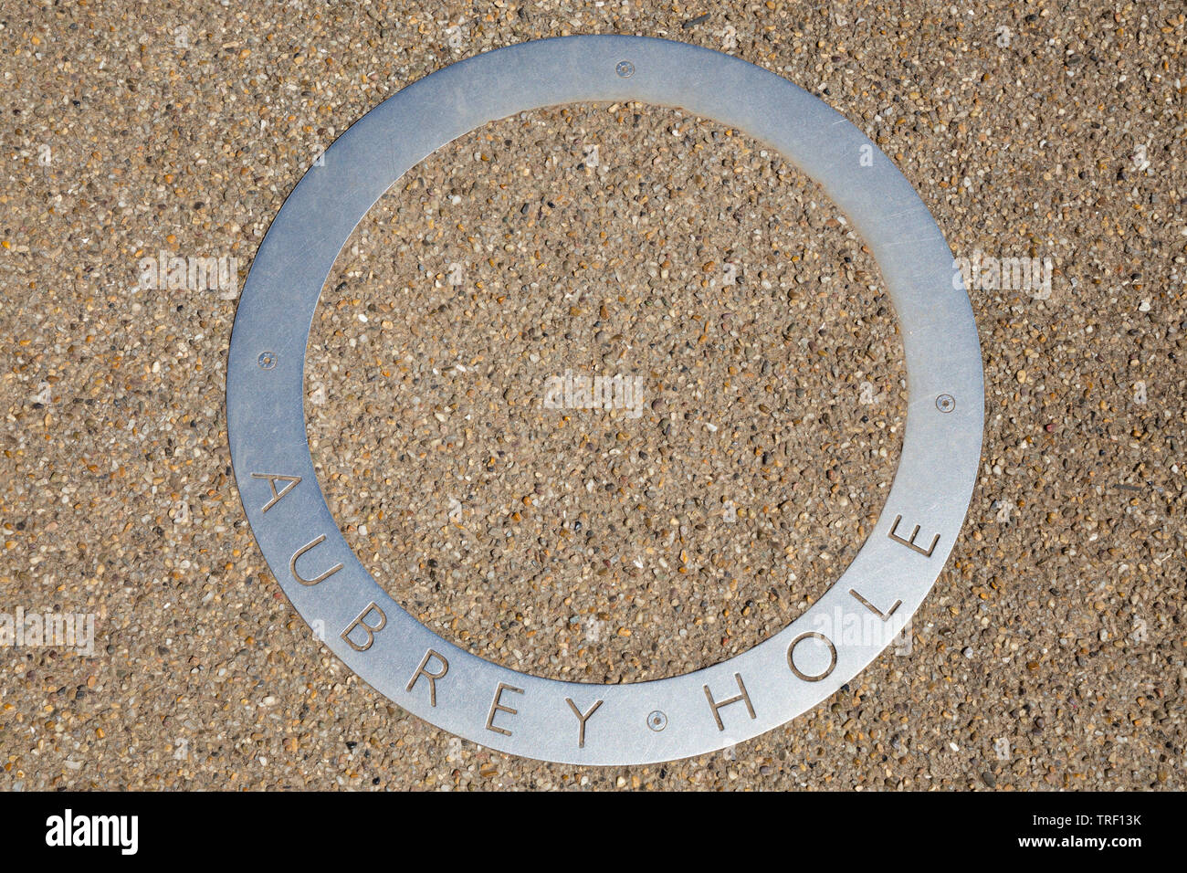 Circle / circular stainless steel Aubrey Hole marker on the tourist path which surrounds Stonehenge. Amesbury, Wiltshire, UK. (109) Stock Photo