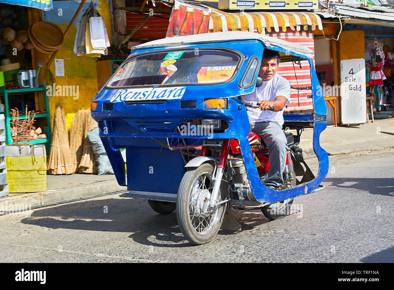 Puerto Princesa City, Palawan, Philippines: Blue cabin tricycle with driver looking at camera, typical mode of transport in Palawan Stock Photo