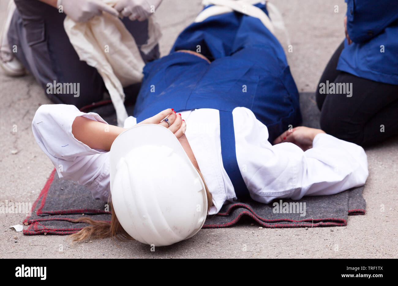 First aid training detail - helping an injured worker after a workplace accident Stock Photo