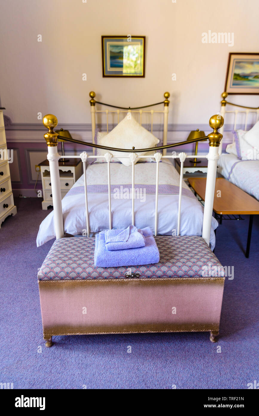 Old fashioned metal single bedstead in an bedroom decorated in Victorian style. Stock Photo