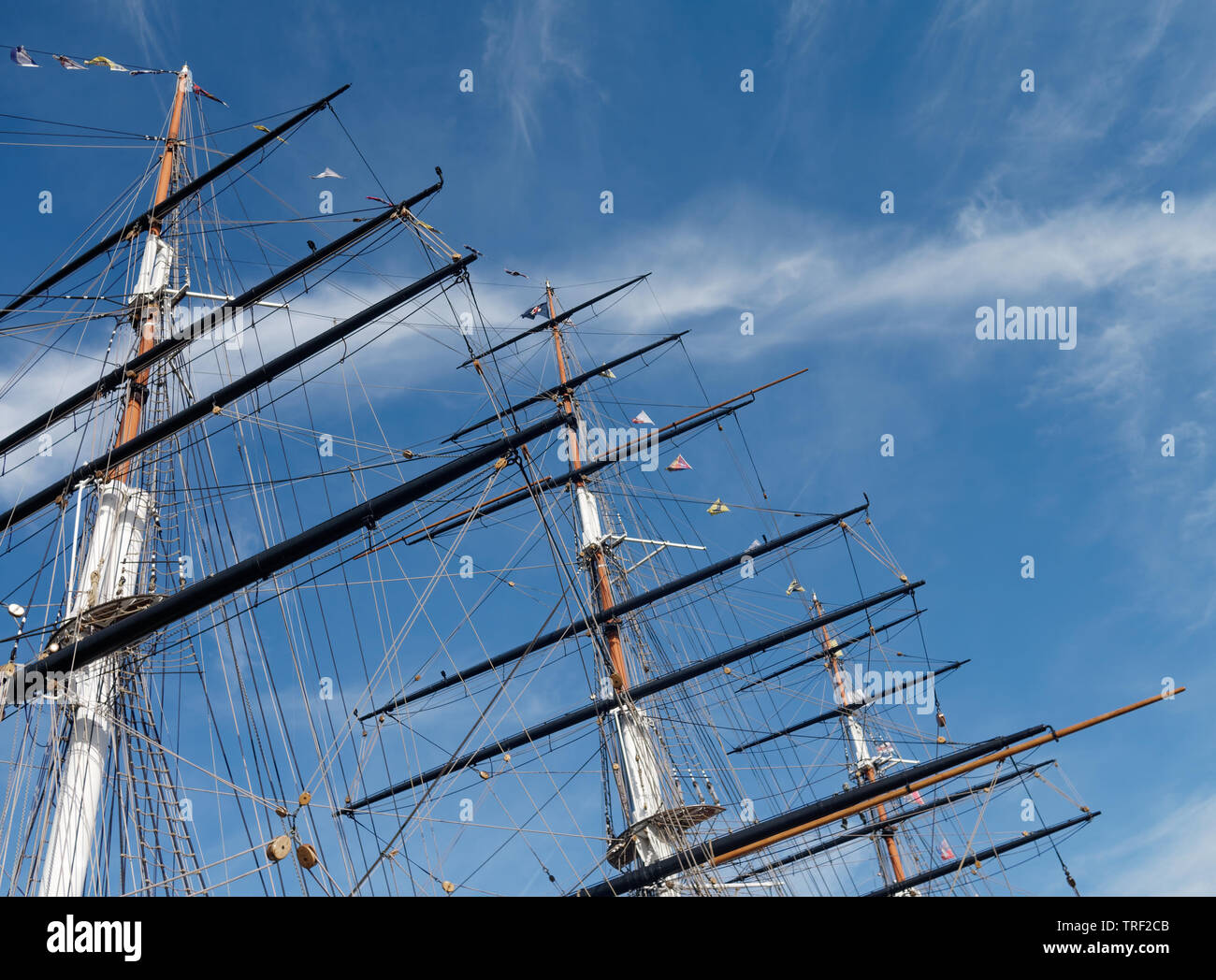 Masts and rigging of a sailing ship against a bright blue sky. Focused ...