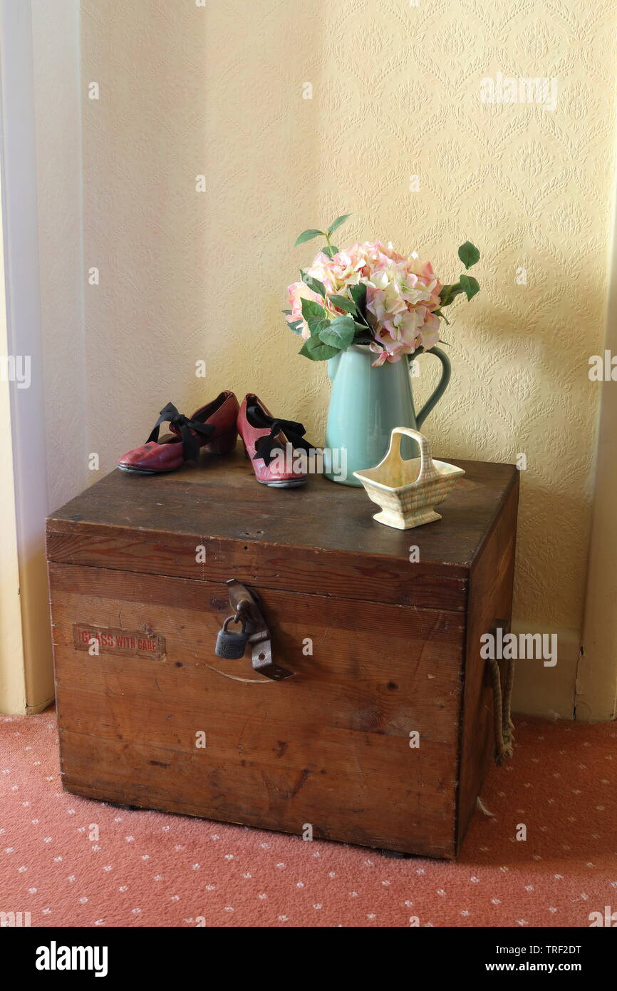 Seaman’s trunk with red tap shoes, 2 pots and some flowers Stock Photo