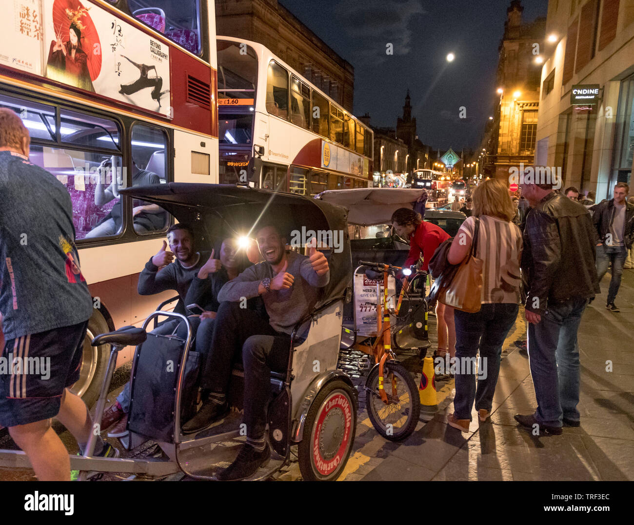 Rickshaw passengers during edinburgh festival Stock Photo