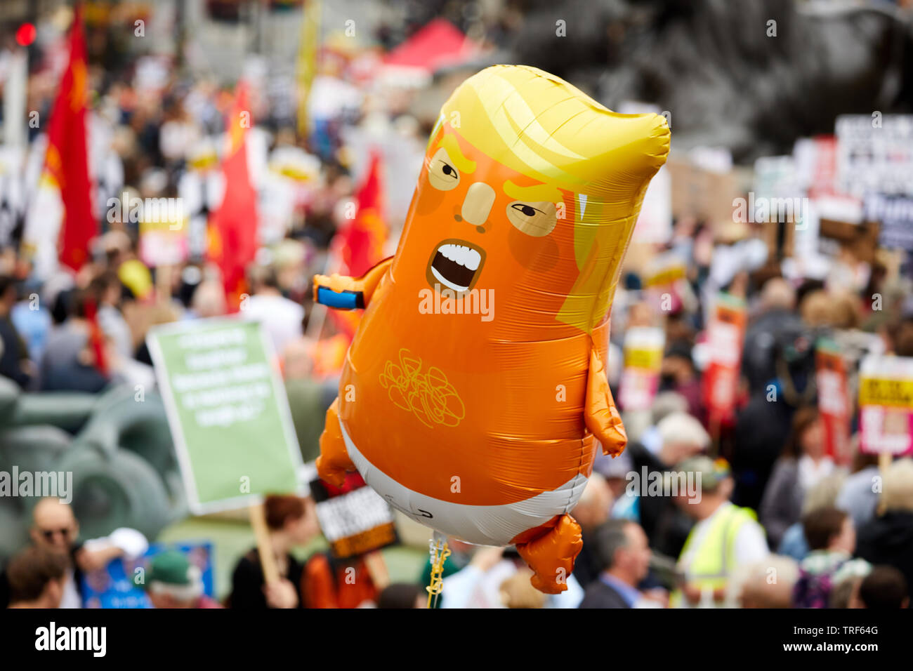 London, UK. - 4 June 2019: A small ballon mocking US President Donald Trump floats above crowds in  Trafalgar Square during a demonstration against his visit of to the UK. Stock Photo
