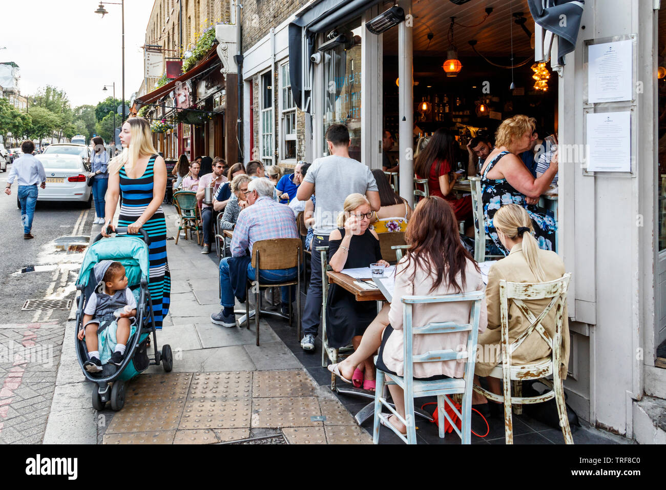 Alfresco diners outside La Farola and other restaurants on Theberton Street, off Upper Street, London, UK Stock Photo