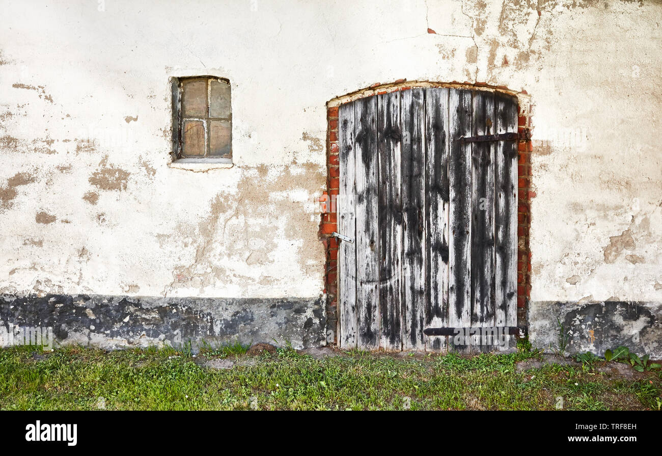Old wooden closed door of an abandoned house. Stock Photo