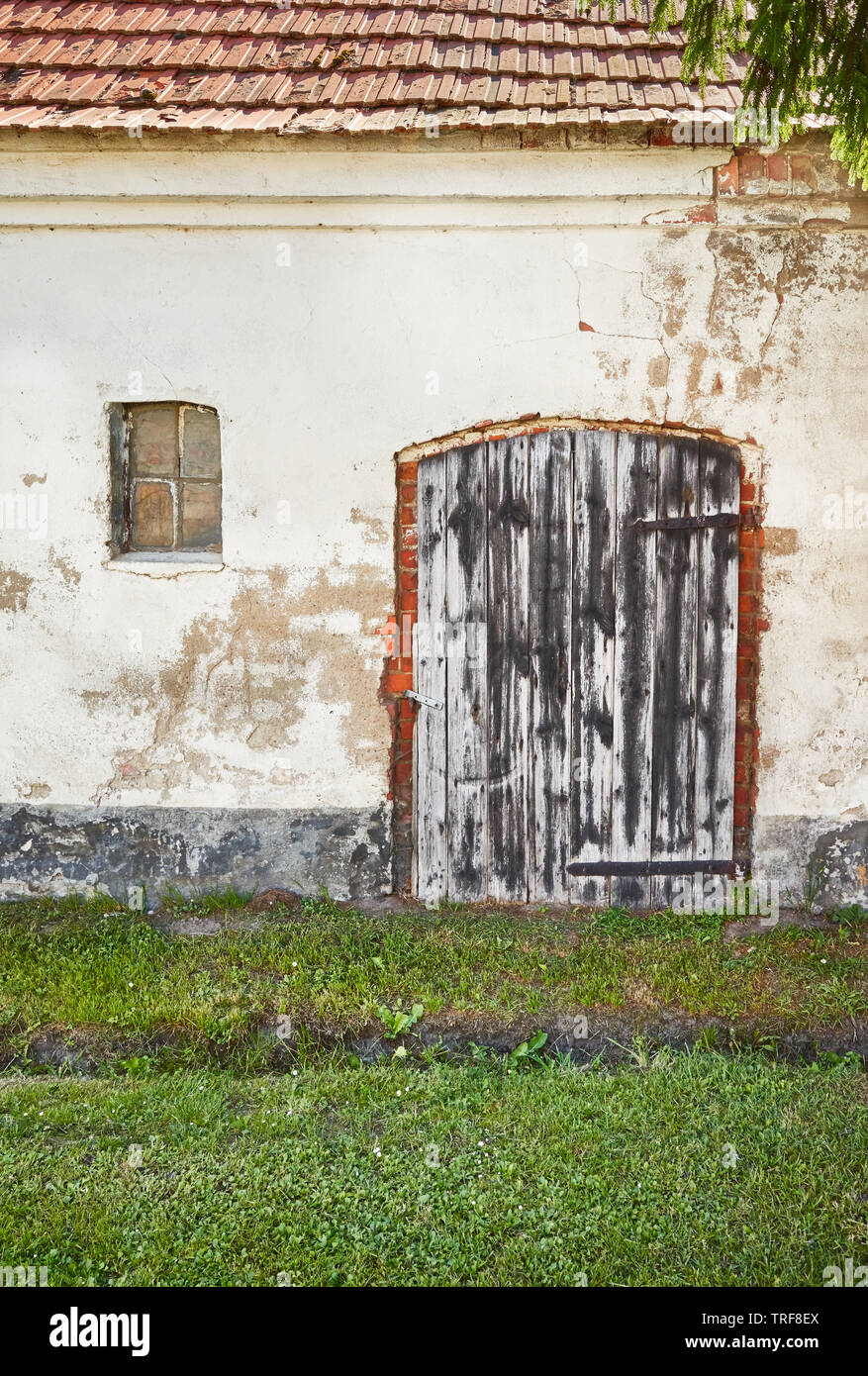Old wooden closed door of an abandoned house. Stock Photo