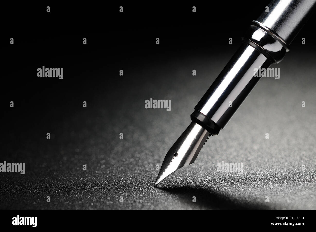 Old fountain pen on a black textured background Stock Photo