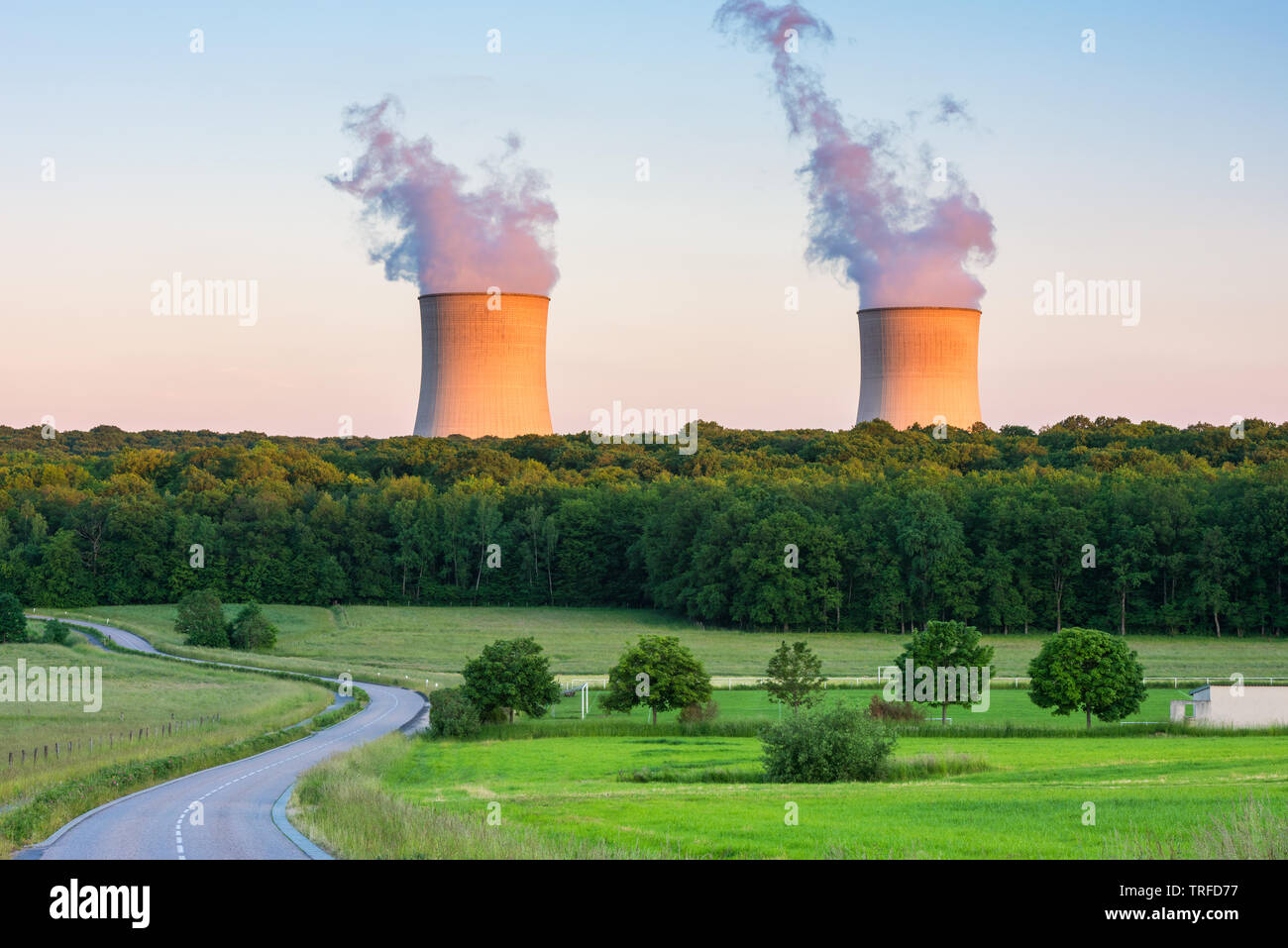 Steaming Cooling Towers at Nuclear Power Plant around Sunset Stock Photo