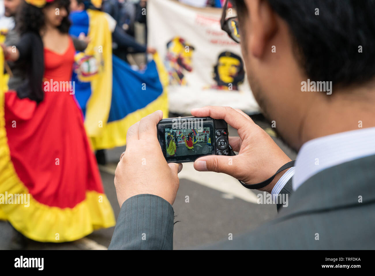 4th June 2019. London, UK. Anti Trump rally in Westminster. A man records on his old camera colourful Cuban dancers. Stock Photo
