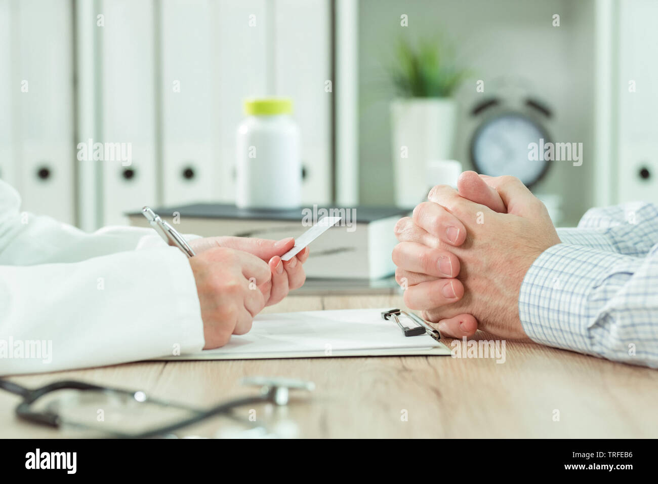 Doctor taking medical insurance card from patient in office during scheduled checkup Stock Photo