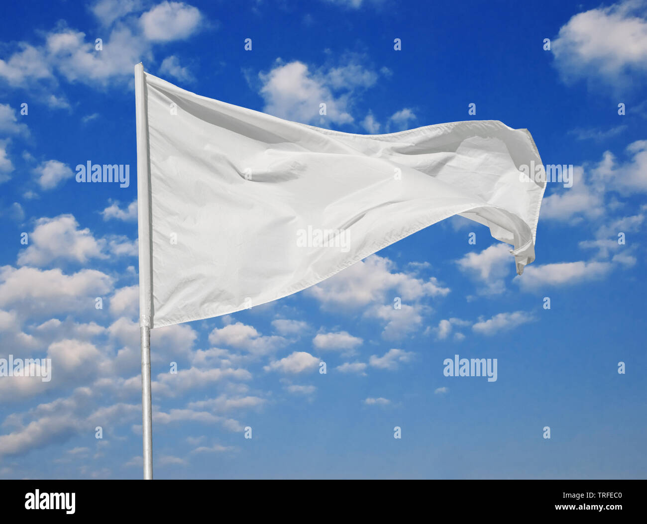 White flag against a blue sky with clouds fluttering in the wind Stock ...
