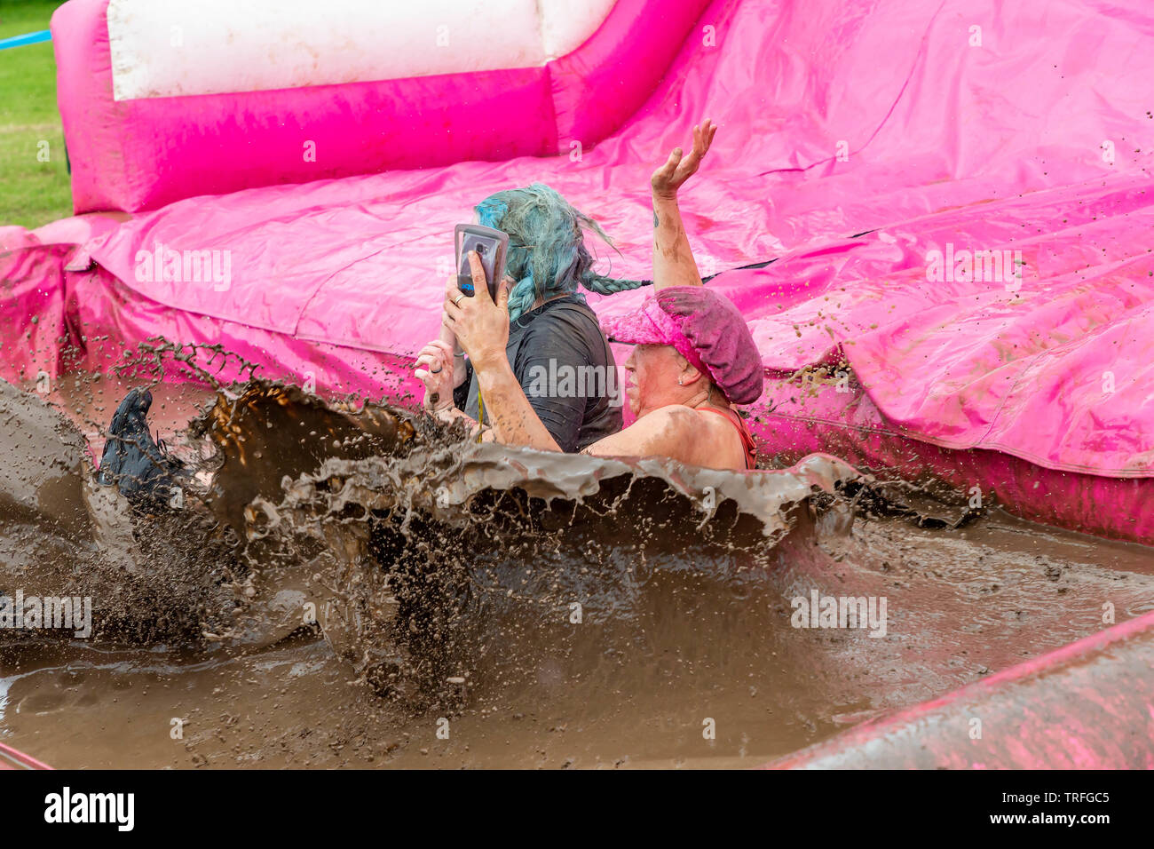 Warrington, UK. 2nd June 2019. Race for Life 2019, Warrington, in aid of Cancer Research. Woman taking selfie as her and friend enter the mud pit Stock Photo