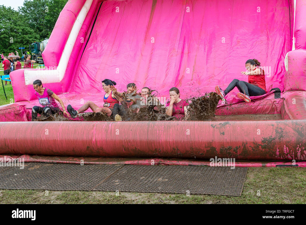 Warrington, UK. 2nd June 2019. Race for Life 2019, Warrington, in aid of Cancer Research. 6 friends slide into the mud pit together Stock Photo