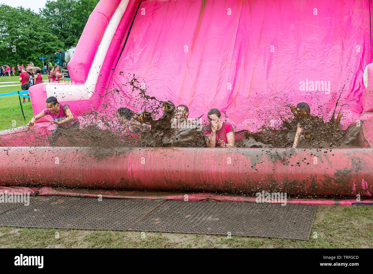 Warrington, UK. 2nd June 2019. Race for Life 2019, Warrington, in aid of Cancer Research. 6 friends slide into the mud pit together Stock Photo