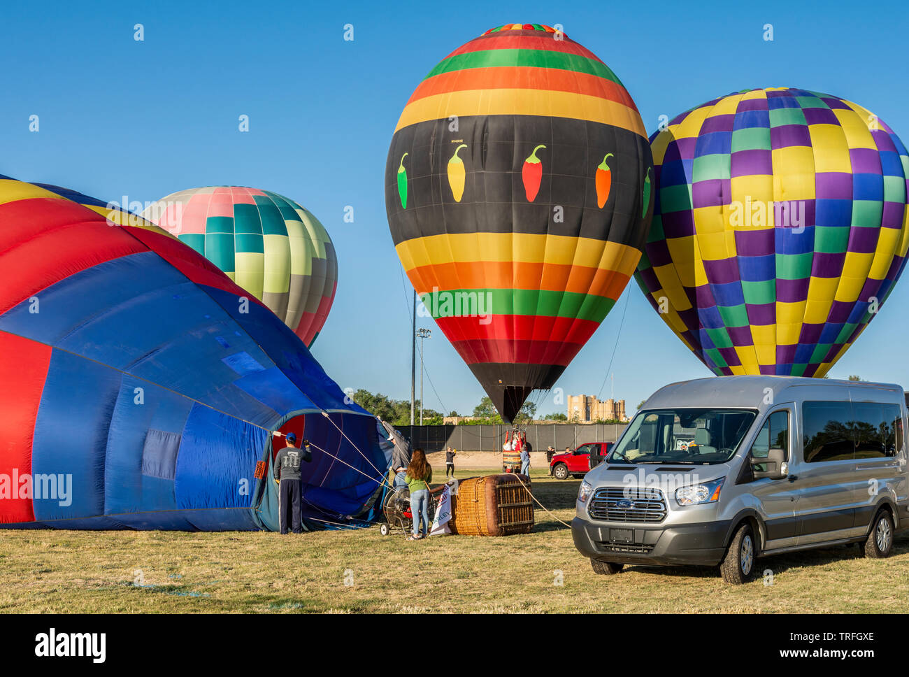 Colorful hot air balloons inflating with crew people at a New Mexico festival. Stock Photo