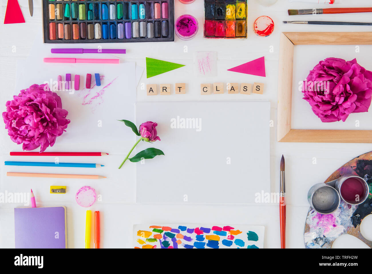 Top view creative artist workplace. Blank Canvas, Art class lettering on  wooden blocks and various colorful painting materials and flowers on white  ba Stock Photo - Alamy