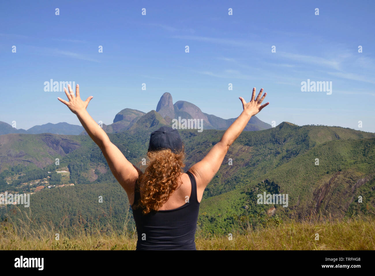 midle age woman on the top of a montain. Concept of success, freedom, joy, self estime, adventure Stock Photo