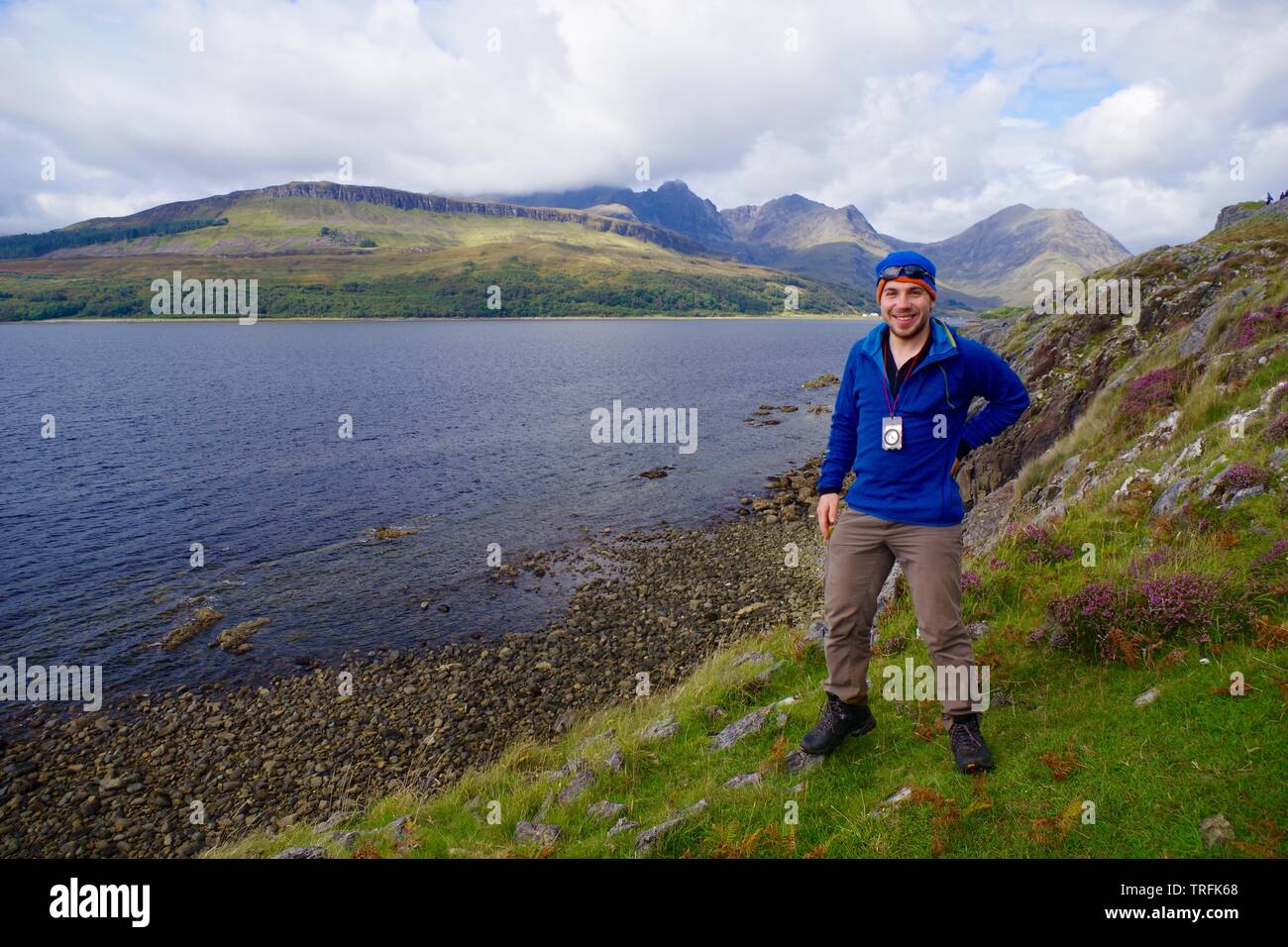 Hiker Posing by Loch Slapin with a View towards the Black Cuillin Mountains. Isle of Skye, Scotland, UK. Stock Photo
