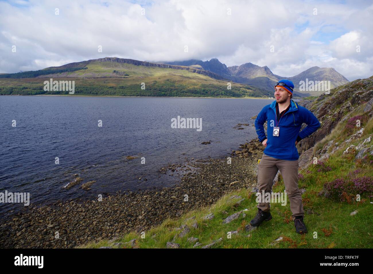 Hiker Posing by Loch Slapin with a View towards the Black Cuillin Mountains. Isle of Skye, Scotland, UK. Stock Photo