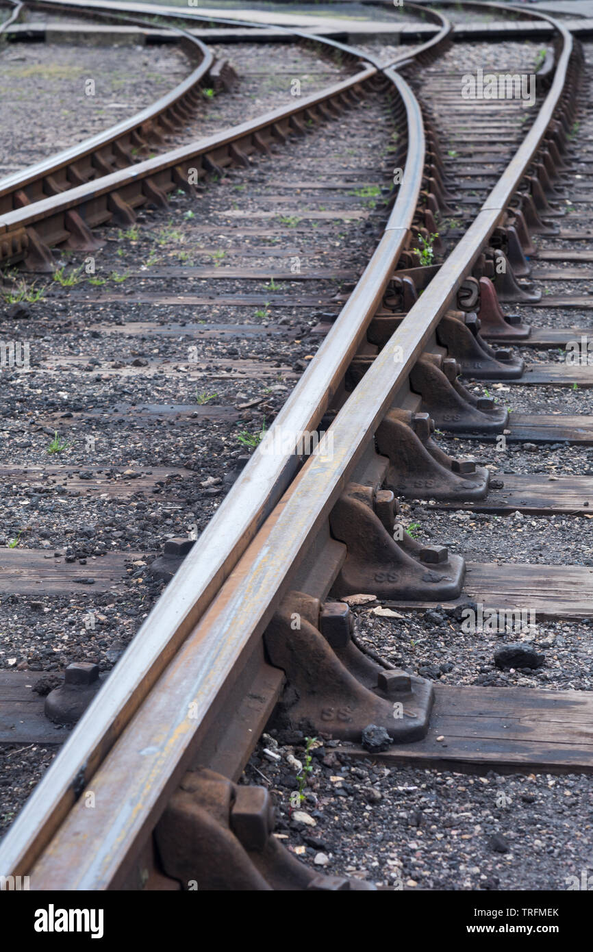 Perspective view of lines of hot rolled steel railway tracks, links, fasteners, sleepers and ballast at Didcot Railway Centre, Oxfordshire, UK Stock Photo